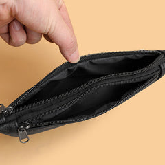 Black leather waist bag open interior showing zippered compartments, close-up detail
