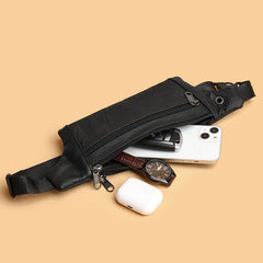 Black leather waist bag capacity reference with phone, watch, earbuds, car key outside, high-angle flat lay