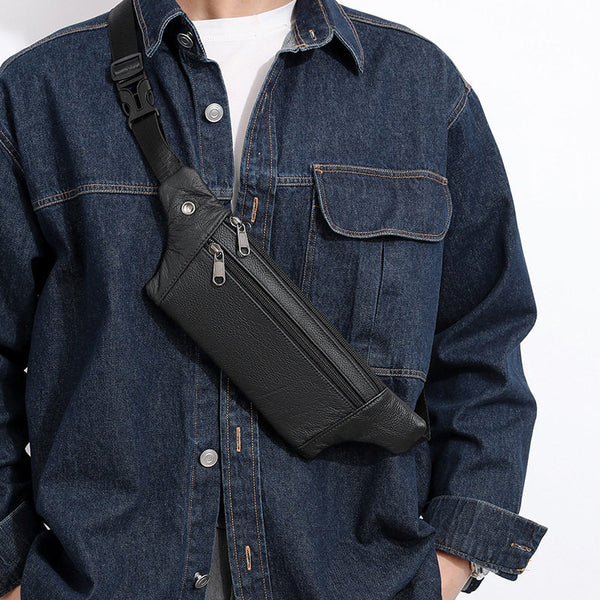 Black leather fanny pack worn as crossbody chest sling, model in dark denim, front view