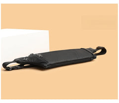 Black leather waist bag slim profile and strap hardware detail, low side angle on peach background