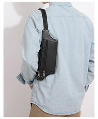 Black leather sling bag worn vertically at the back under the arm, rear side view
